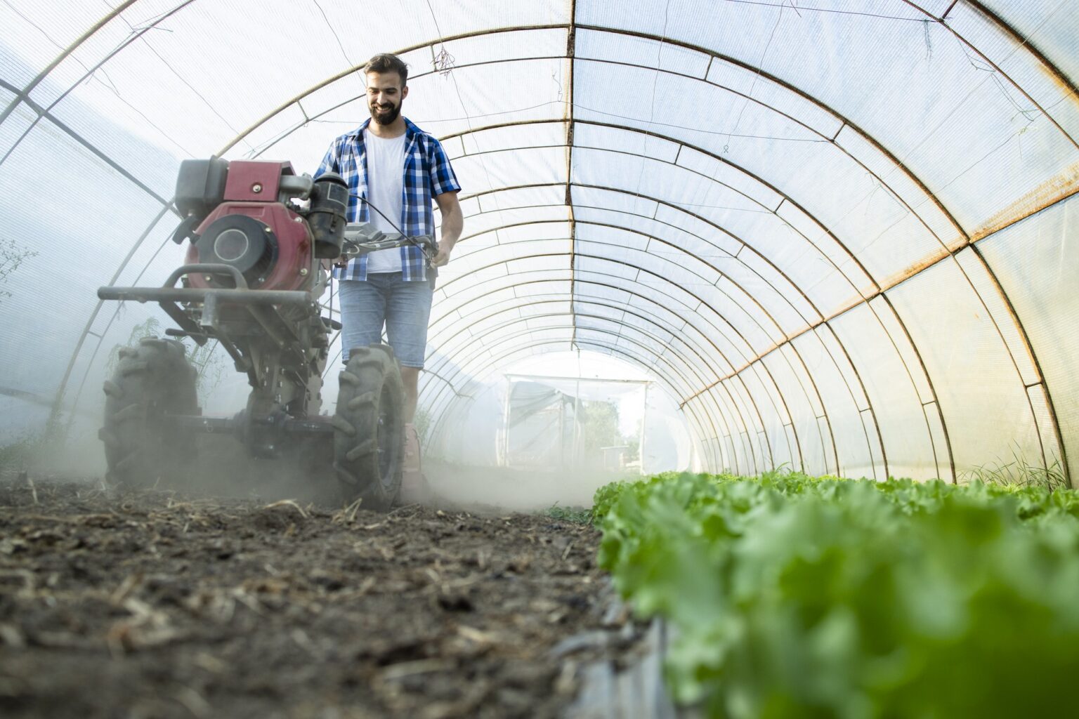 hardworking-young-farmer-operating-motor-cultivator-prepare-soil-new-seedlings-organic-food-farm